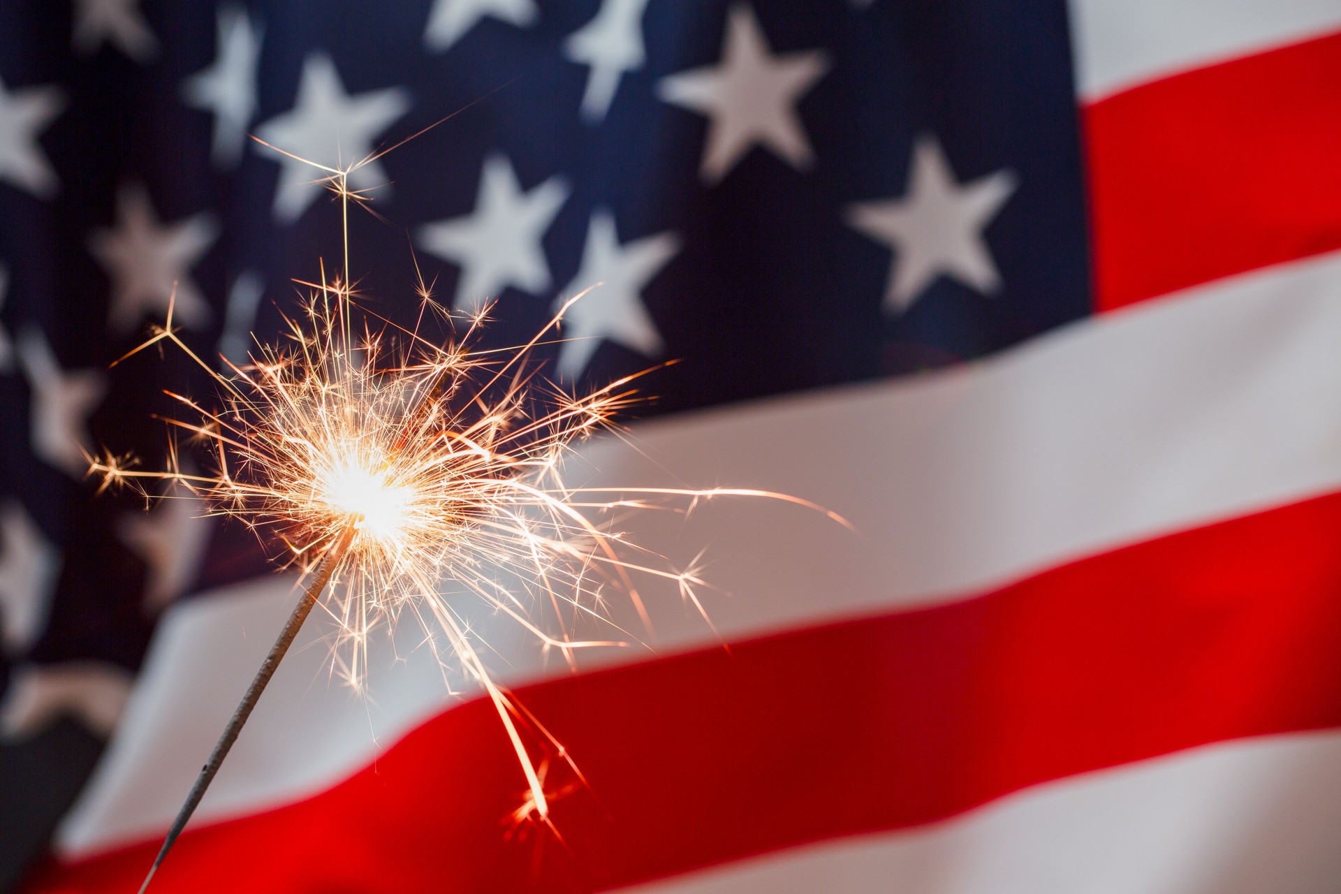 Sparkles with lights and American flag on the background. July forth celebration. The Independence day backdrop. Minimalistic wallpaper with copy space