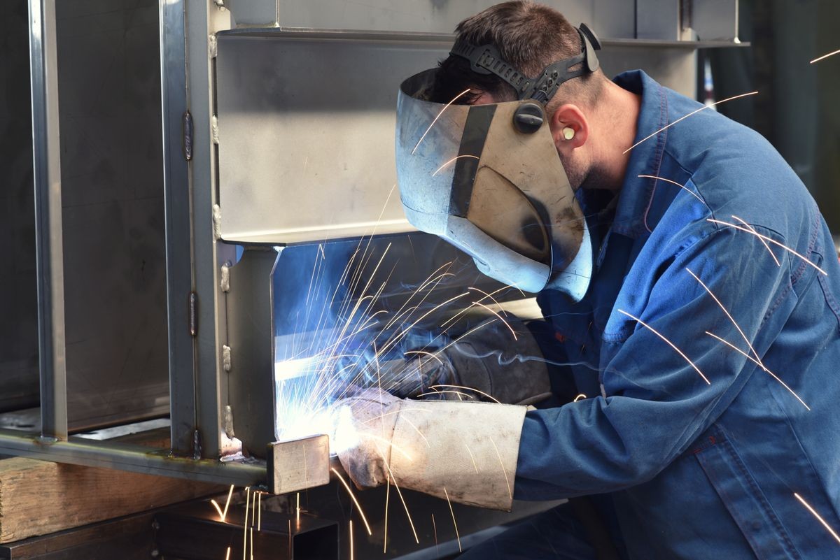 welder works in metal construction - construction and processing of steel components 